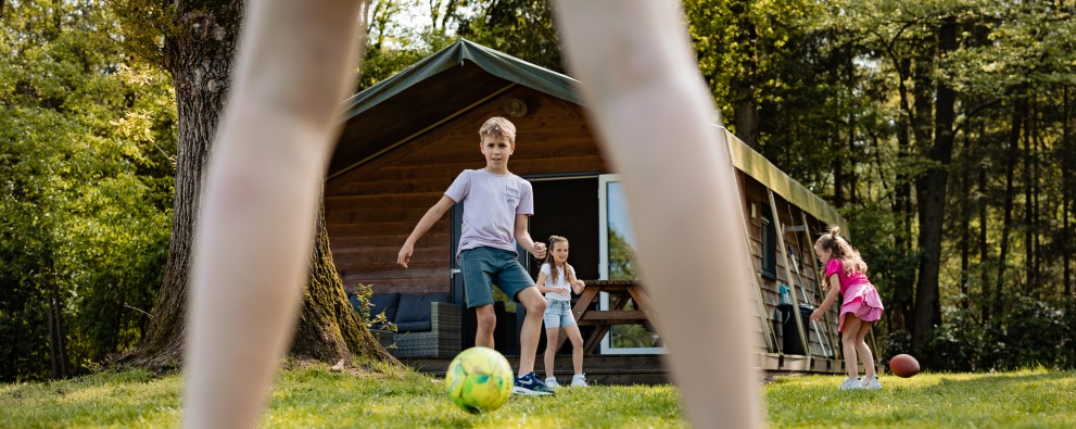 Safarilodge- voetbal spelen voor de tent.jpg